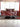 Luxury kitchen with red marble-effect glass splashback, modern white cabinets, and sleek black countertop