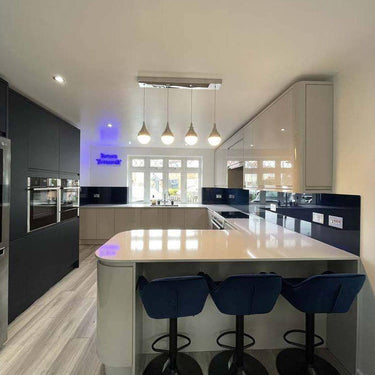 Modern kitchen with LED backlit glass feature wall and sleek island bar