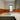 Vibrant orange glass backsplash in modern kitchen with grey cabinets and white countertop