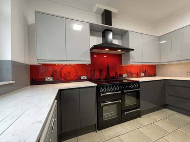 Red London skyline glass backsplash in modern kitchen with black range cooker and grey cabinets