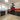 Modern kitchen with red cityscape glass splashback, sleek grey cabinets, and black appliances