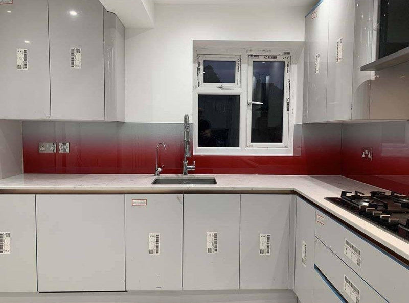 Modern kitchen with red gradient glass splashback, sleek grey cabinets, and white countertop