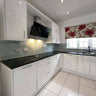 Modern kitchen with white gloss cabinets, black countertop, and glass splashback for luxury residential interiors