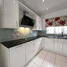 Modern kitchen with white gloss cabinets, black countertop, and glass splashback for luxury residential interiors