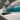 Teal LED backlit glass kitchen splashback with modern cabinetry and gas hob