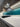 Teal LED backlit glass kitchen splashback with modern cabinetry and gas hob