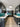 Modern kitchen with teal glass splashback, dark wood cabinets, and marble countertops