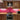 Vibrant pink glass kitchen backsplash with wooden cabinets and stainless steel appliances