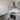 Modern kitchen with sleek grey cabinets, marble-effect countertops, and a frosted glass backsplash.