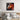 Geometric horse wall art in modern bedroom, featuring bold red and orange tones above a wooden bed.