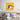 Vibrant abstract eye artwork on bedroom wall, bold yellow and pink geometric background