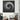 Modern black and white dot pattern wall art in minimalist living room with houndstooth armchair