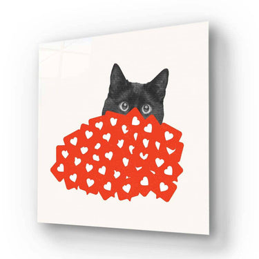 Black cat peeking over red heart-patterned decorative glass panel