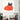Black cat peeking over red heart-patterned wall art in modern living room