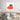 Black cat peeking over red heart-patterned glass art in modern bedroom