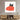 Black cat peeking over red heart-patterned art on modern living room wall