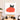 Black cat peeking over red heart-patterned glass art in modern dining room