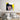 Pop art canvas print of woman on phone, bold yellow background, above modern bed in bedroom