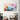 Abstract pastel cloud art print on modern living room wall with checkered armchair