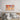 Vibrant orange and blue abstract wall art above modern bed in minimalist bedroom