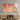 Vibrant orange and blue abstract art glass panel mounted on textured wall above wooden media console