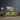 Abstract wall art above yellow sofa in modern living room with decorative plants and wood side tables