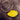 Yellow autumn leaf floating on dark water with ripple effect