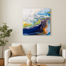 Modern living room with beige sofa, decorative pillows, potted plant, and abstract blue-yellow wall art