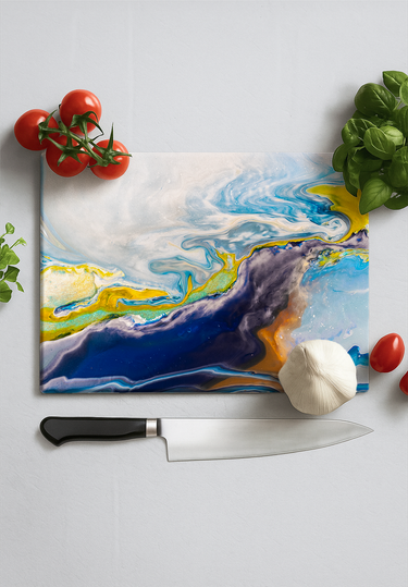Galaxy-themed glass chopping board with chef knife, tomatoes, garlic, and fresh basil on white surface