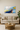 Abstract galaxy wall art with blue, yellow, and white swirls above beige sofa in modern living room