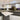 Modern kitchen with sleek grey glass island, white countertops, and pendant lighting
