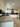 Modern kitchen with sleek white cabinets, concrete countertop, and glass backsplash for luxury residential design