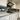 Modern kitchen with sleek white cabinets, stainless steel range hood, and reflective glass backsplash