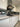 Modern kitchen with sleek white cabinets, stainless steel range hood, and reflective glass backsplash
