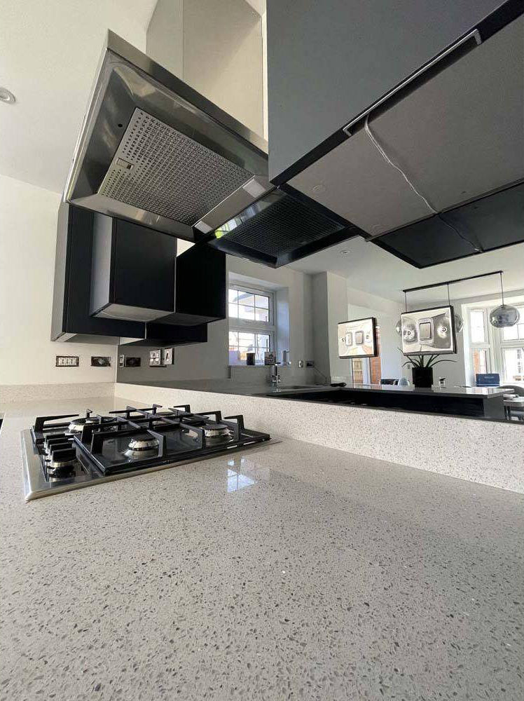 Modern kitchen with sleek glass backsplash and stainless steel range hood