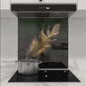 Custom glass kitchen splashback with golden feather design, modern induction cooktop, sleek range hood