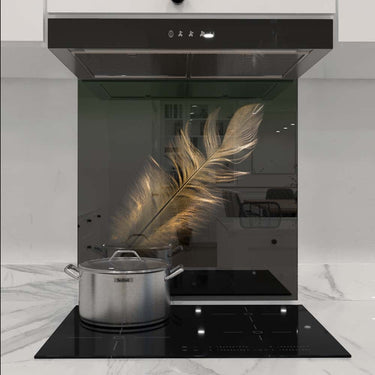 Custom glass kitchen splashback with golden feather design, modern induction cooktop, sleek range hood