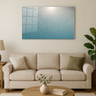Modern living room with beige sofa, round wooden coffee table, green plant, and gradient teal wall art