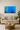Modern beige living room with blue abstract ice cave wall art, sofa, wooden coffee table, and green plant