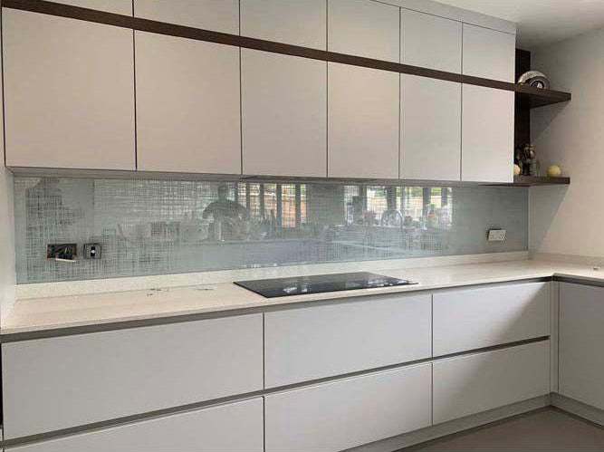 Modern kitchen with frosted glass backsplash and sleek white cabinetry