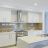 Modern kitchen with sleek white cabinets, stainless steel range hood, and glass backsplash