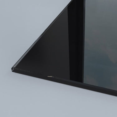 Sleek black glass panel corner, showcasing precision edge detailing for modern architectural installations