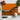 Orange cutting board with abstract black, white, and blue design, surrounded by cherry tomatoes, garlic, basil, and a chef's knife