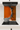 Modern kitchen stovetop with stainless steel pot and orange backsplash with black and white abstract design