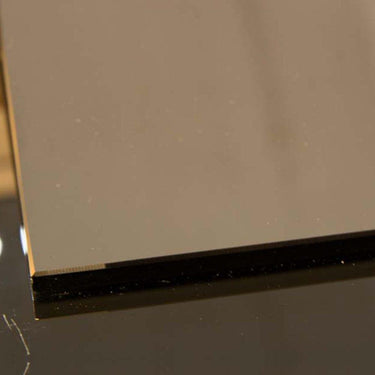 Close-up of sleek, polished glass edge with black backing, ideal for modern architectural glass installations.