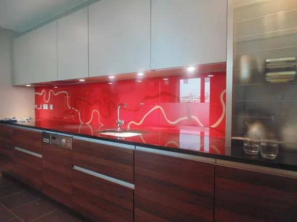 Vibrant red glass splashback with white wave design in modern kitchen, sleek cabinets and underlighting