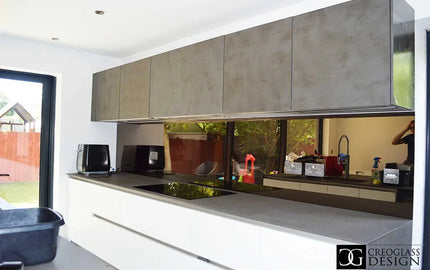 Modern kitchen with sleek concrete-style glass splashback and minimalist white cabinetry