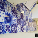 Bespoke decorative glass wall with blue and white patterned tiles for commercial interiors