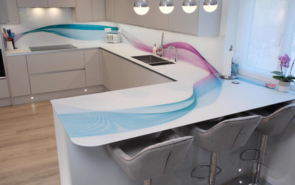 Bespoke kitchen with wave-patterned decorative glass splashback and island, featuring blue and pink hues for modern luxury design.
