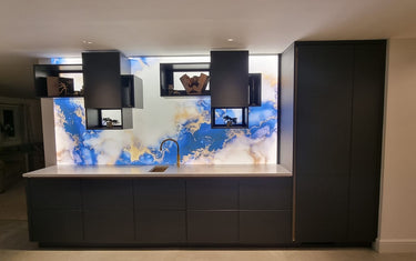 Bespoke blue and gold marbled glass backsplash in modern kitchen with LED lighting
